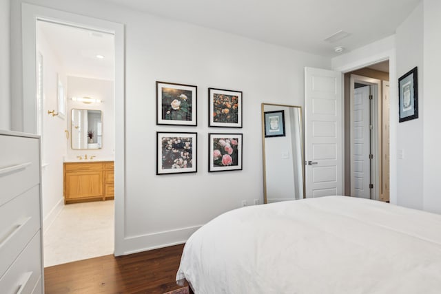 bedroom featuring dark hardwood / wood-style floors, sink, and connected bathroom