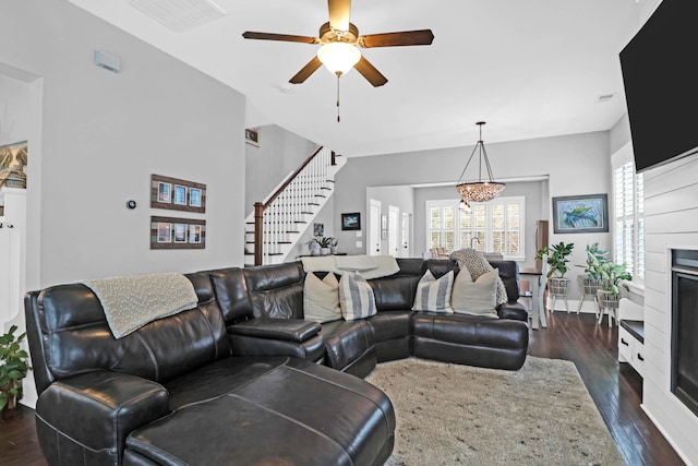 living room featuring ceiling fan with notable chandelier and dark hardwood / wood-style flooring