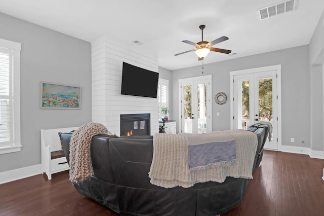 living room with ceiling fan, french doors, a multi sided fireplace, and dark hardwood / wood-style floors