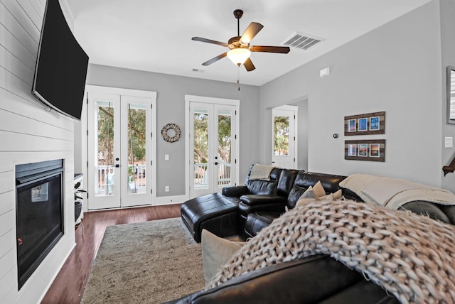 living room with french doors, ceiling fan, and dark wood-type flooring