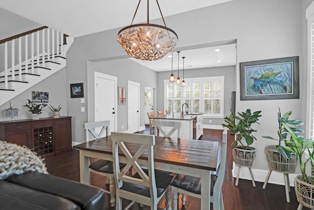 dining area featuring sink, an inviting chandelier, and dark wood-type flooring