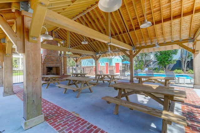 view of patio / terrace with an outdoor brick fireplace and a community pool