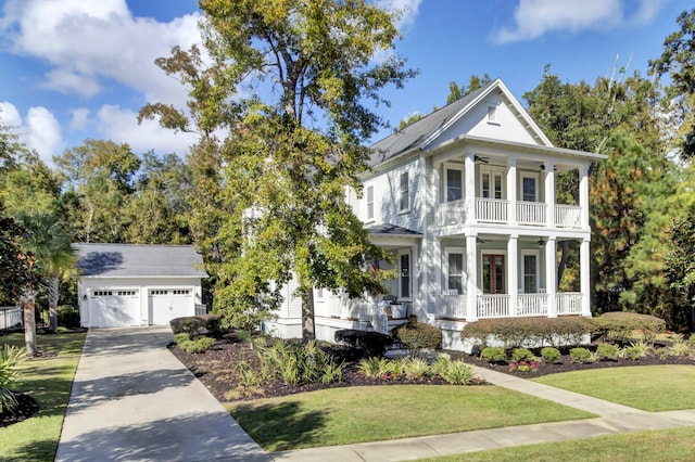 view of front of property featuring covered porch, an outdoor structure, a front yard, and a garage