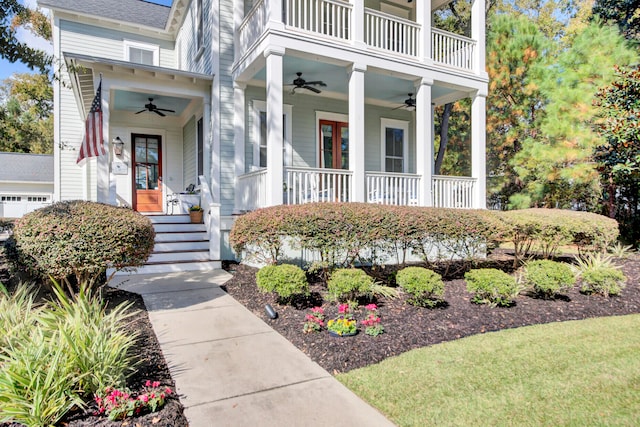 doorway to property featuring covered porch, ceiling fan, and a yard