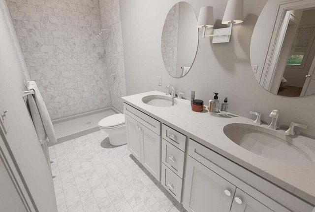 bathroom with a tile shower, vanity, and toilet