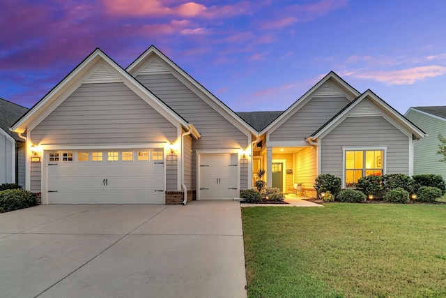 view of front of property with a garage and a lawn