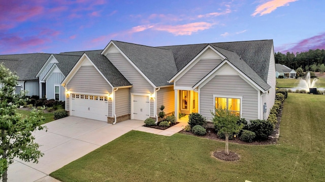 view of front of property with a garage and a lawn