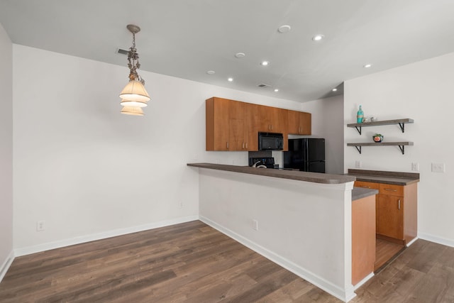 kitchen with kitchen peninsula, dark wood-type flooring, black appliances, and decorative light fixtures