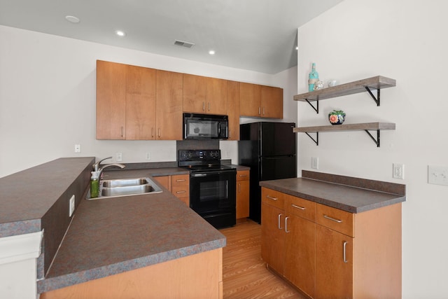 kitchen featuring kitchen peninsula, sink, black appliances, and light wood-type flooring