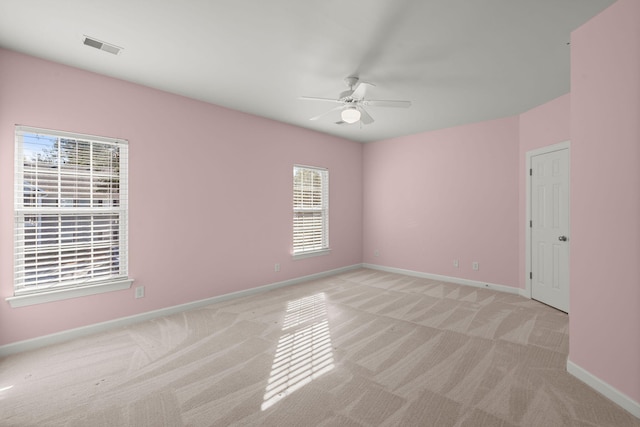 carpeted empty room featuring a wealth of natural light and ceiling fan