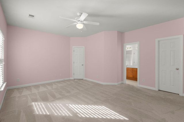 unfurnished bedroom featuring ensuite bath, ceiling fan, and light carpet