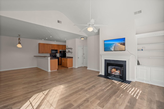 unfurnished living room with lofted ceiling, built in shelves, ceiling fan, and dark hardwood / wood-style floors