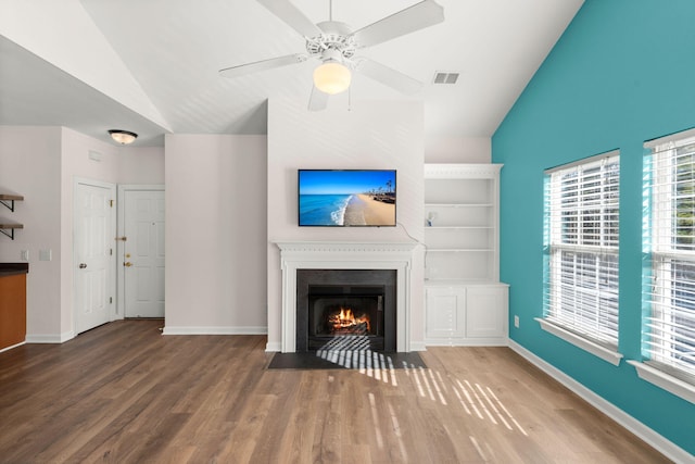 unfurnished living room featuring ceiling fan, built in features, wood-type flooring, and vaulted ceiling