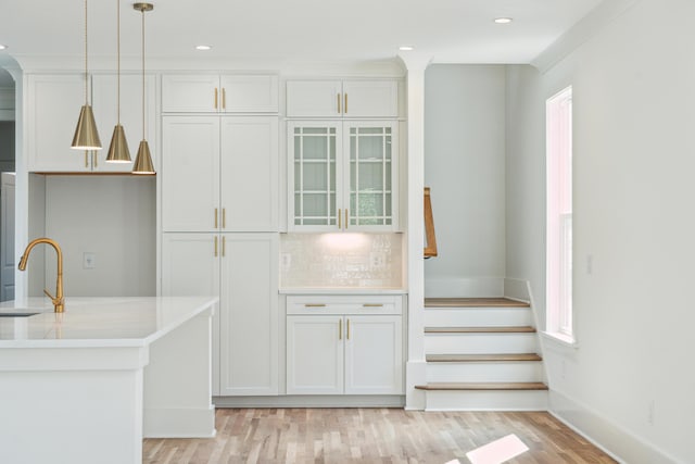 kitchen with backsplash, a wealth of natural light, white cabinetry, and pendant lighting