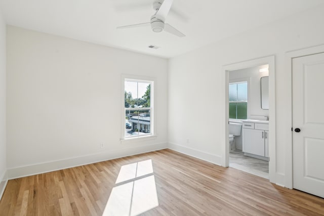 unfurnished bedroom with light hardwood / wood-style flooring, ensuite bath, and ceiling fan