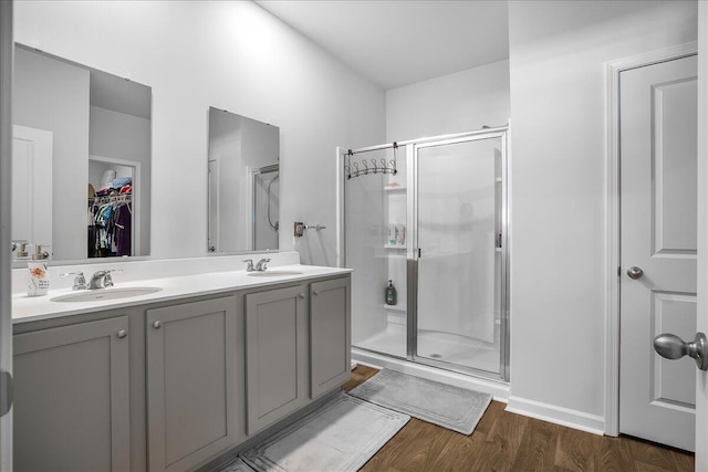 bathroom with vanity, a shower with shower door, and hardwood / wood-style flooring