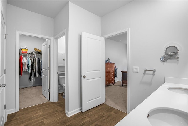 bathroom with hardwood / wood-style floors, vanity, and toilet