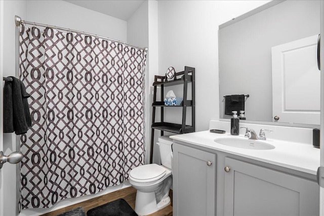 bathroom featuring a shower with shower curtain, vanity, wood-type flooring, and toilet