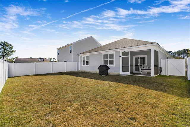 back of house featuring a sunroom and a yard