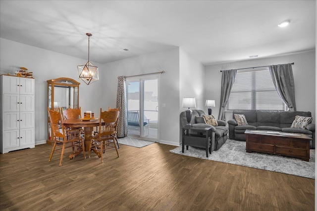 dining space featuring dark hardwood / wood-style flooring and a chandelier