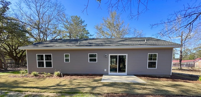 rear view of house featuring a patio area, fence, and a lawn