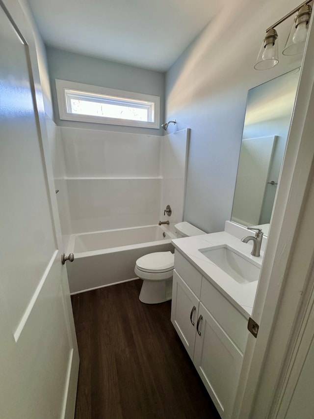 bathroom with toilet, bathing tub / shower combination, wood finished floors, and vanity