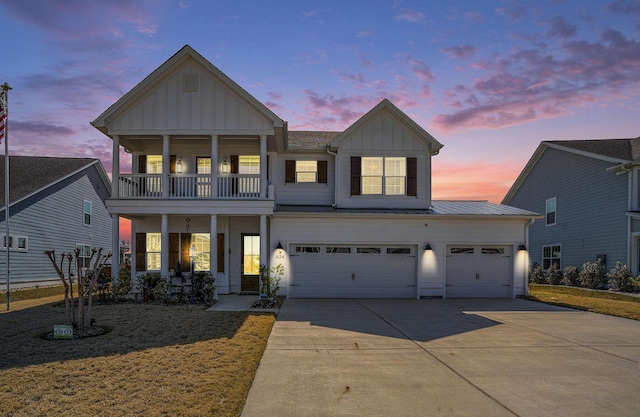 view of front of house featuring driveway, a standing seam roof, board and batten siding, metal roof, and a balcony