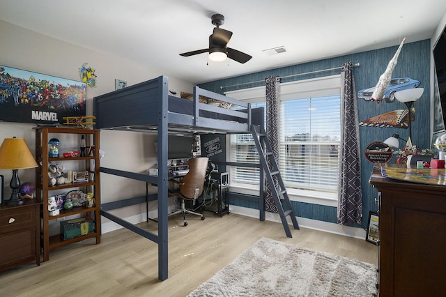 bedroom featuring visible vents, baseboards, ceiling fan, and wood finished floors