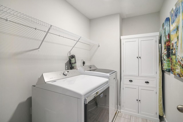 laundry room with washer and clothes dryer and cabinet space