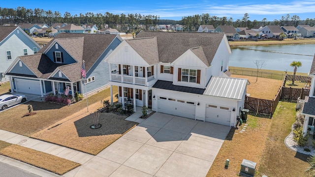 view of front of home featuring fence, a residential view, concrete driveway, an attached garage, and metal roof