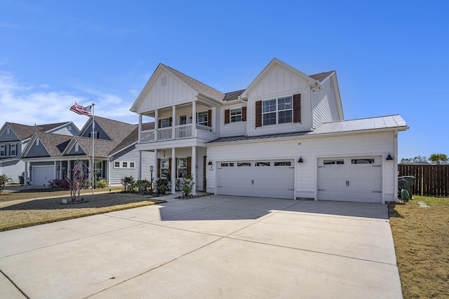 view of front of property featuring driveway, a standing seam roof, board and batten siding, a garage, and a balcony