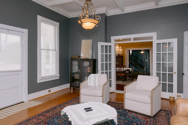 living room featuring ornamental molding, beamed ceiling, a wealth of natural light, and wood finished floors