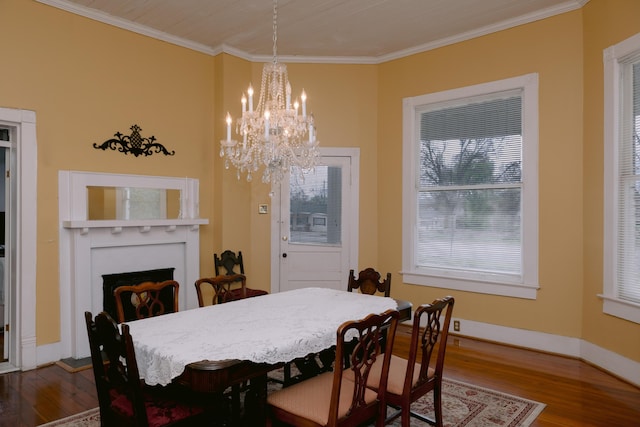 dining space with crown molding, dark wood-style floors, an inviting chandelier, and a fireplace