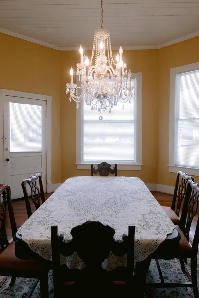 dining room featuring baseboards, wood finished floors, a notable chandelier, and crown molding