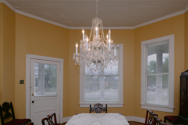 dining room with ornamental molding, an inviting chandelier, and baseboards