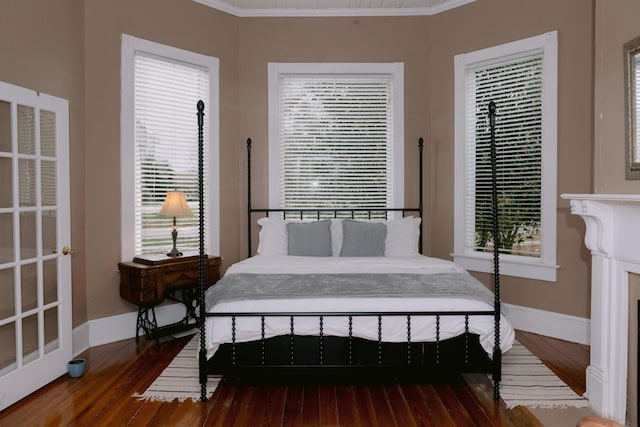 bedroom with wood-type flooring, ornamental molding, and baseboards