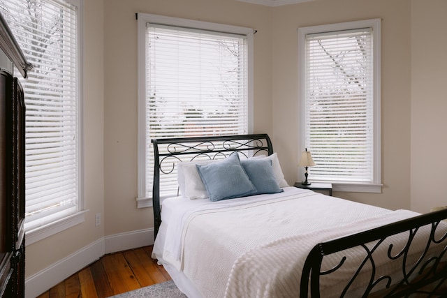 bedroom with hardwood / wood-style floors, multiple windows, and baseboards
