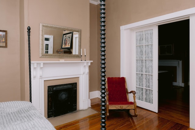 sitting room with a fireplace, wood finished floors, and baseboards