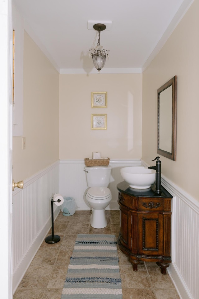 bathroom featuring wainscoting, ornamental molding, toilet, and vanity
