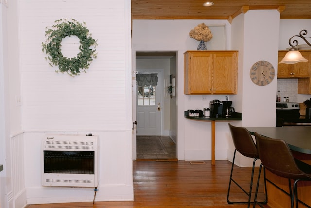 kitchen with hardwood / wood-style flooring, dark countertops, heating unit, stainless steel electric range, and backsplash