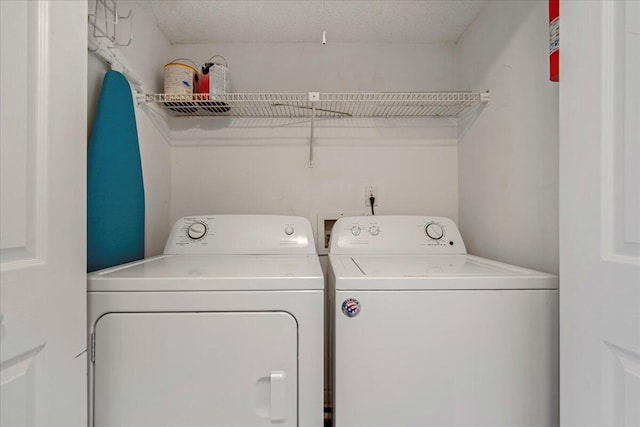 washroom with washer and dryer and a textured ceiling