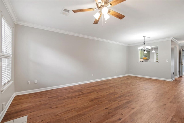 unfurnished room with wood-type flooring, ceiling fan with notable chandelier, ornamental molding, and plenty of natural light