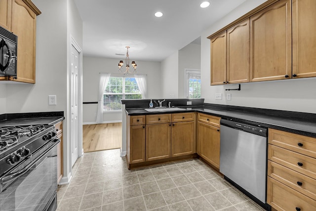 kitchen featuring black appliances, a peninsula, a chandelier, a sink, and dark countertops