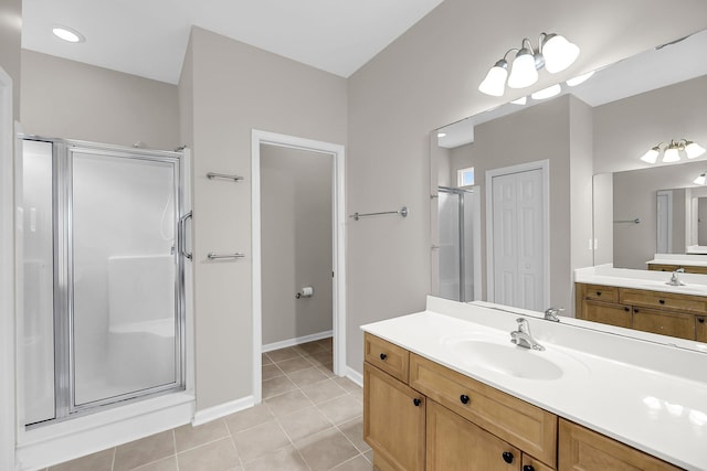 bathroom featuring a stall shower, tile patterned flooring, vanity, and baseboards