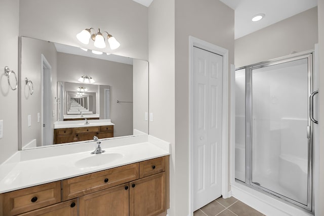 full bath with a stall shower, tile patterned flooring, vanity, and a closet