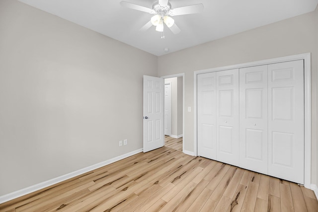 unfurnished bedroom with light wood-type flooring, baseboards, a closet, and ceiling fan
