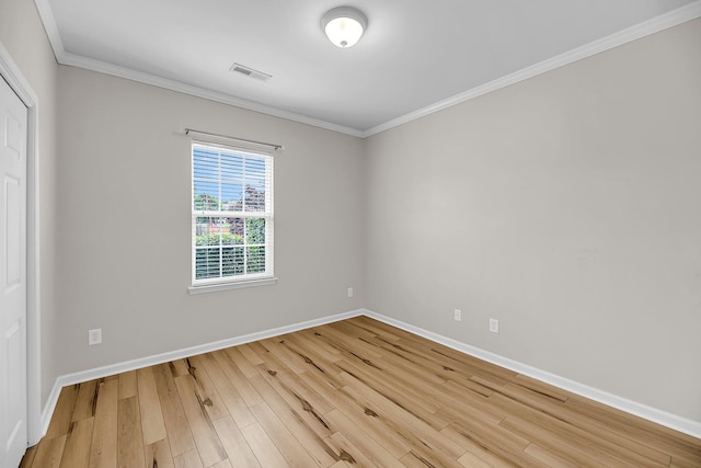 spare room with baseboards, wood finished floors, and ornamental molding
