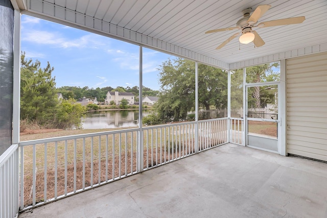 unfurnished sunroom featuring a water view and ceiling fan