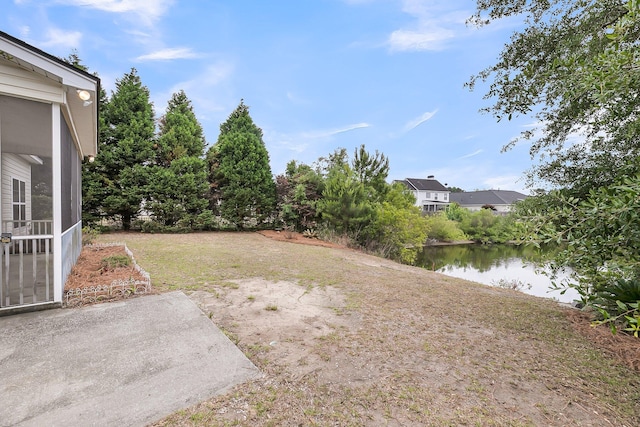 view of yard with a water view and a patio