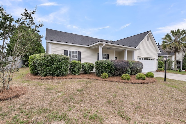 view of front of property with concrete driveway, a shingled roof, covered porch, and a garage